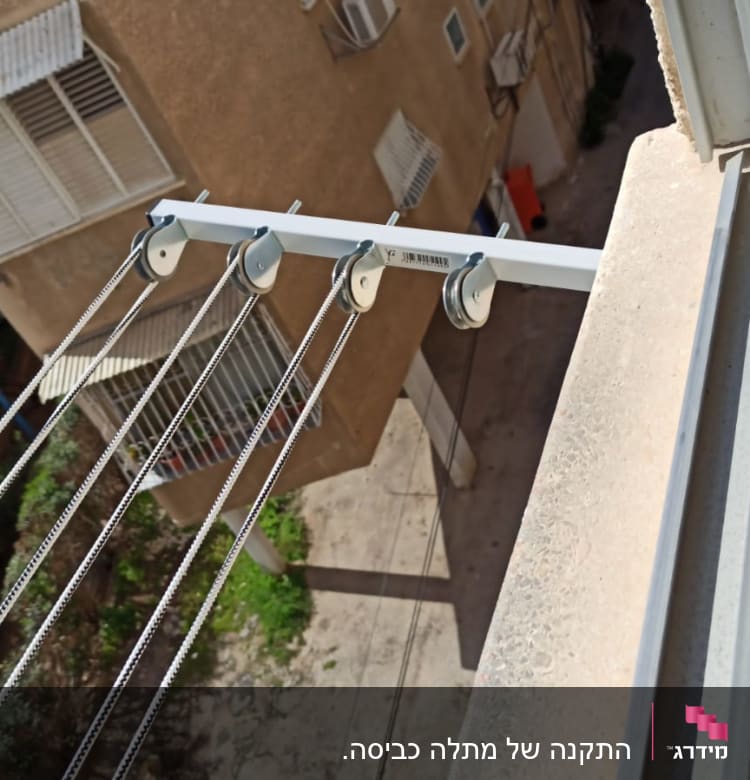 חבלי כביסה תלויים על גלגלות מתכת מחוץ לחלון